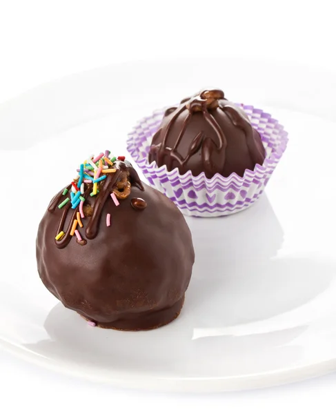 Deliciosos caramelos de chocolate con virutas de colores en la espalda blanca — Foto de Stock
