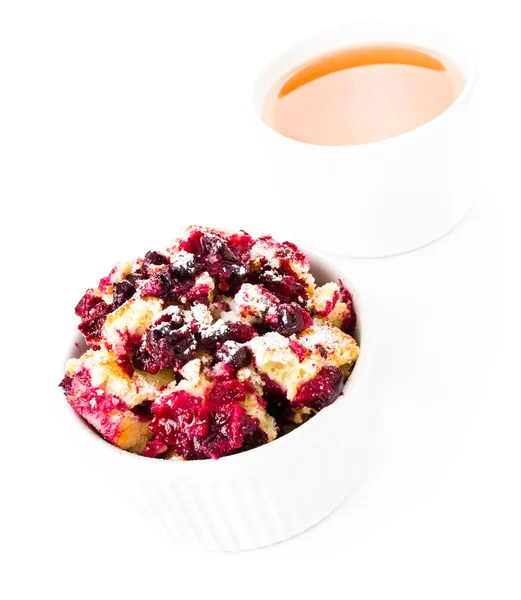 Fruit fresh crumble dessert in a white bowl with a cup of tea — Stock Photo, Image