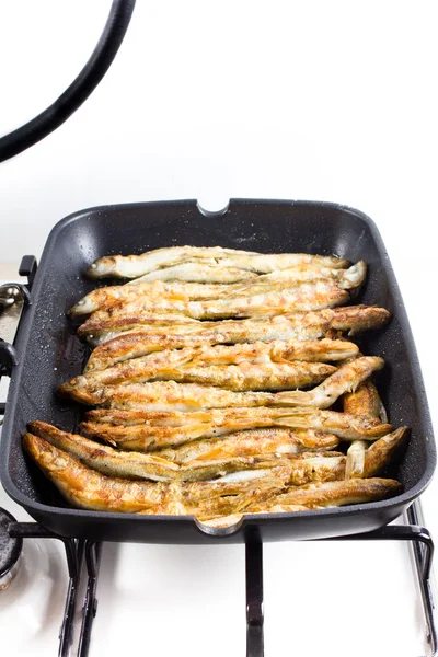 Fried small smelt fish on a barbecue grill hotplate — Stock Photo, Image