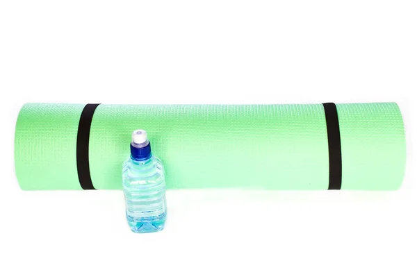 Lätt skum yoga matta rulle med flaska vatten på vit — Stockfoto