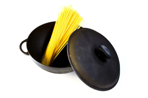 Black cast iron pot with raw pasta, isolated on a white — Stock Photo, Image