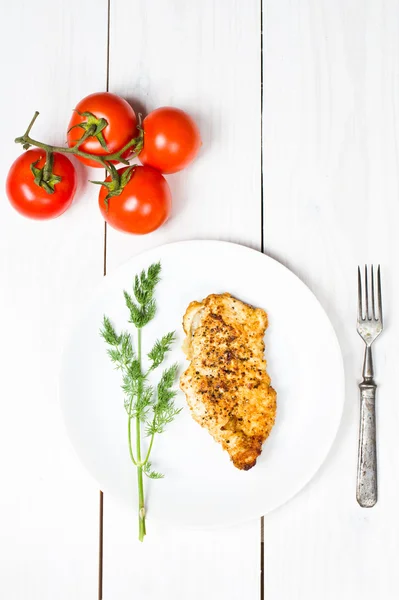 Seios de frango saborosos grelhados em uma placa branca com tomates frescos e ervas — Fotografia de Stock