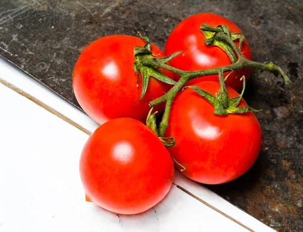 Pęczek świeżych dojrzałych pomidorów na ciemne tło — Zdjęcie stockowe