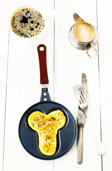 Fried eggs in funny shape of penis in a frying pan with black coffee — Stock Photo, Image