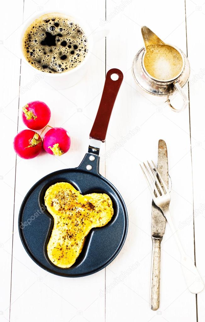 Breakfast with fried eggs in fun form of penis in a frying pan