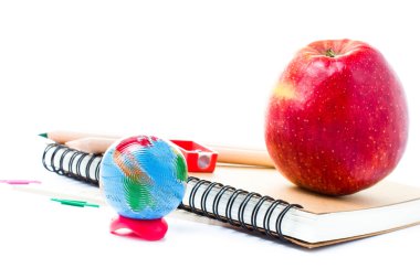 Küre ve beyaz zemin üzerine defter ile okul malzemeleri