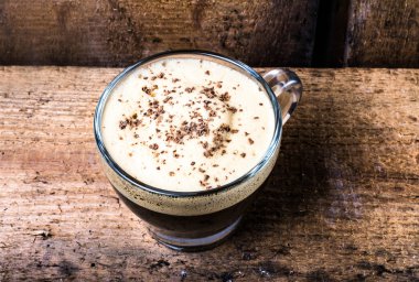 küçük fincan espresso kahve köpüğü ve eski ahşap masa üstünde çikolata ile cam