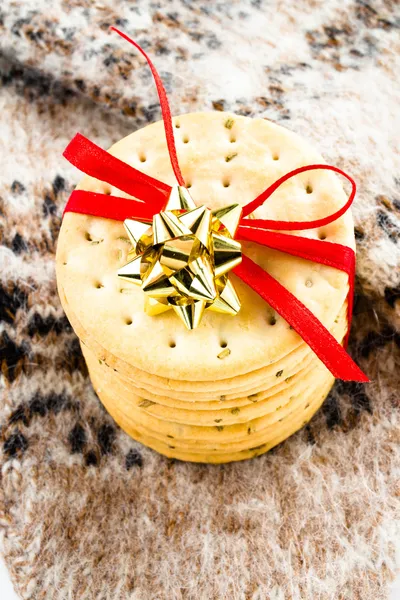 Weihnachtsplätzchen mit roter Schleife und gestricktem Winterhandschuh. — Stockfoto