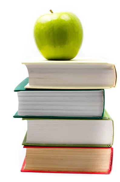 Book heap and green apple on top over white background — Stock Photo, Image