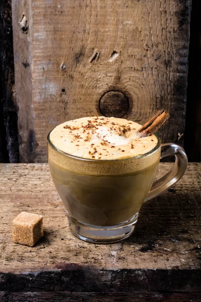 Kávé pohár csésze tejszín, a fahéj és a porcukros csokoládé. — Stock Fotó