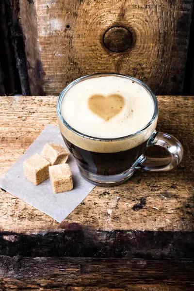 Pequena xícara de café expresso em vidro com coração desenhado em espuma — Fotografia de Stock