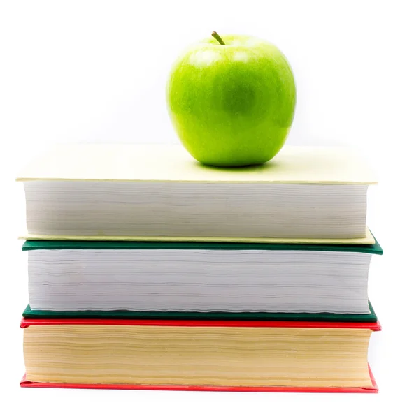 Montón de libros coloridos y manzana sobre fondo blanco . — Foto de Stock