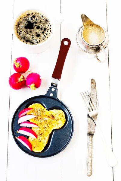 Fried eggs in fun form of man penis in a frying pan with coffee and milk over white wooden background. — Stock Photo, Image