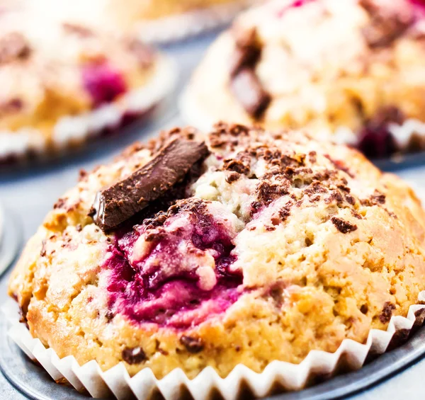 Kirschmuffins mit Schokoladenstreuern in Backform. Makro. — Stockfoto