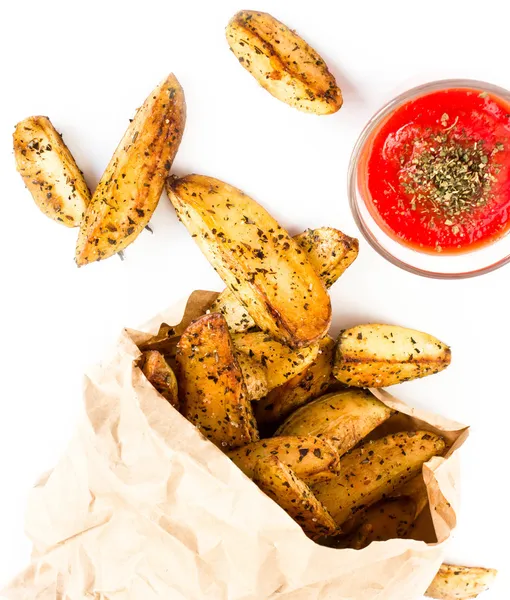 Una pila de papas fritas cuñas de patata en el país estilo ecycled bolsa de papel de envoltura artesanal . — Foto de Stock