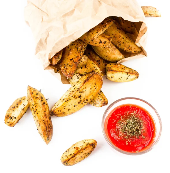 Pommes frites klyftpotatis med stark röd sås i återvunnet kraftpapper — Stockfoto
