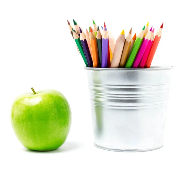 Färgpennor i plåtburk eller pencil innehavare och grönt äpple — Stockfoto