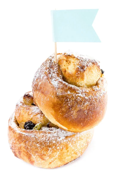 Rolled bun with cinnamon and raisins with paper letter — Stock Photo, Image