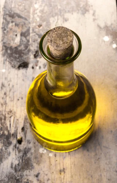 Olivenöl in der Flasche auf rustikalem, antikem Holztisch. — Stockfoto