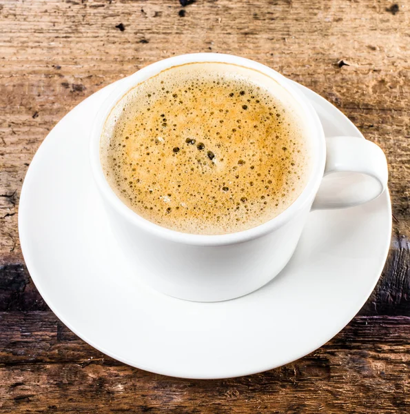 Closeup cup of espresso on old wooden table over grunge background — Stock Photo, Image