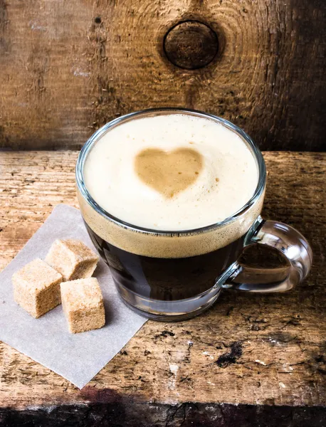 Small cup of espresso coffee in glass with heart drawning on foam. — Stock Photo, Image