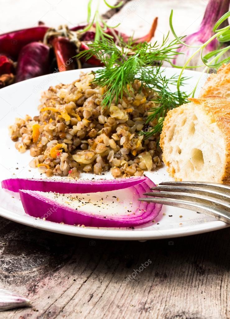 Russian cuisine. Buckwheat porridge, bresd, red onion and herbs.