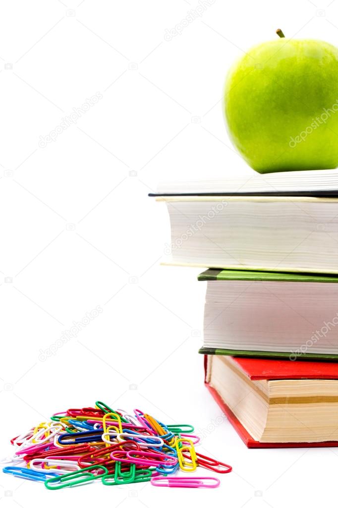 Pile of colorful books and apple on white background.