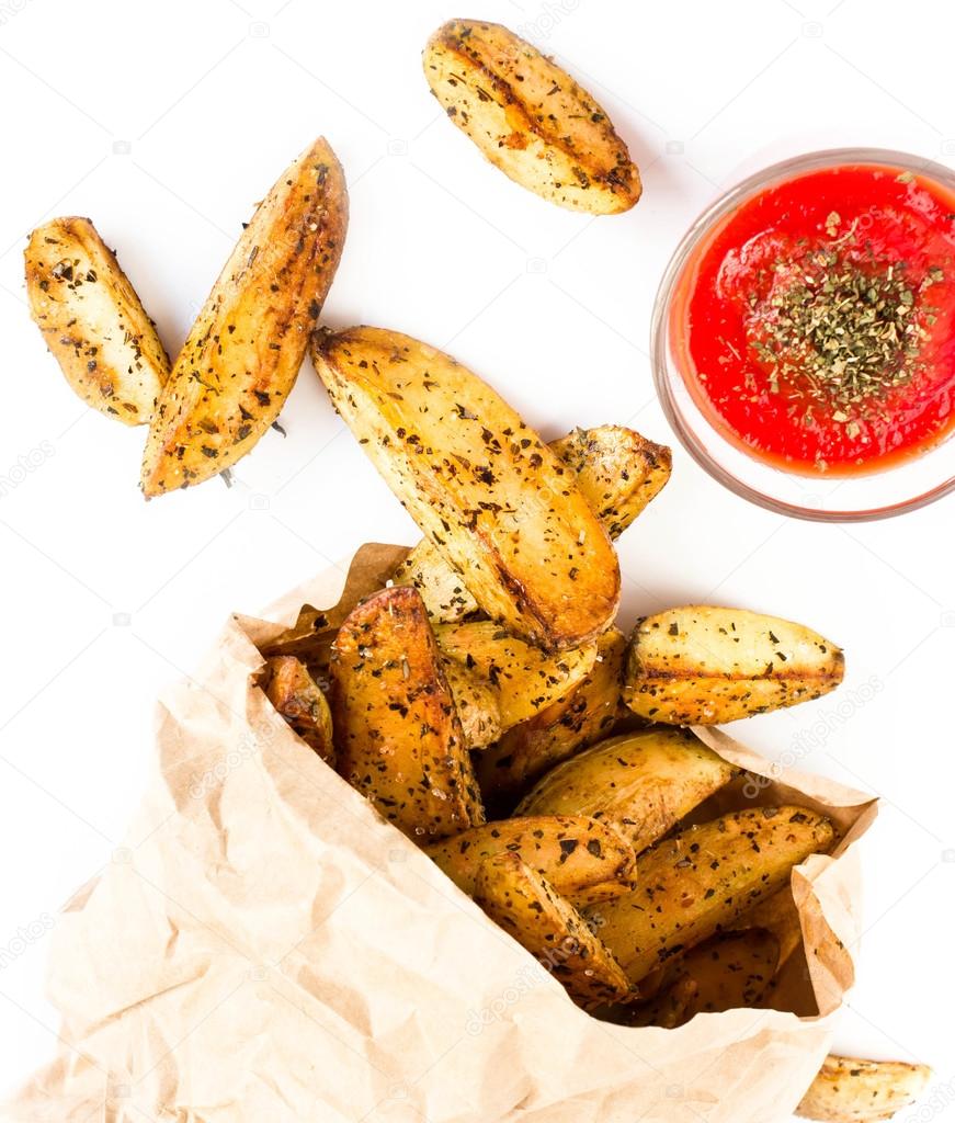 A pile of French fries potato wedges in country styled in ecycled craft paper wrapper bag.