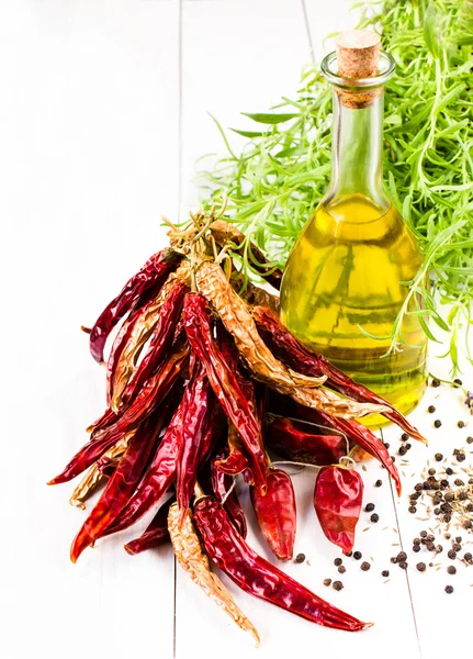Oliwy z oliwek z butelki, zioła i czerwone warzywa na białym tle, — Zdjęcie stockowe