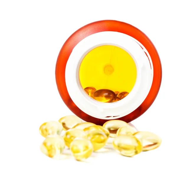 Shiny yellow vitamin E omega 3 fish oil capsules and pill bottle — Stock Photo, Image