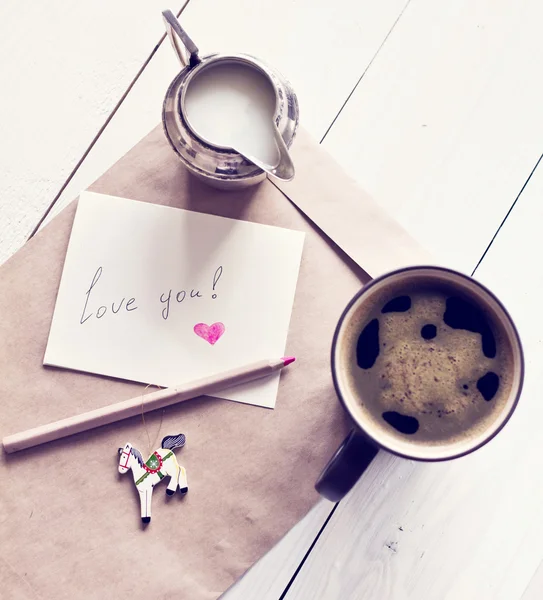 Černá káva v šálku a mléka s kartou a obálka — Stock fotografie