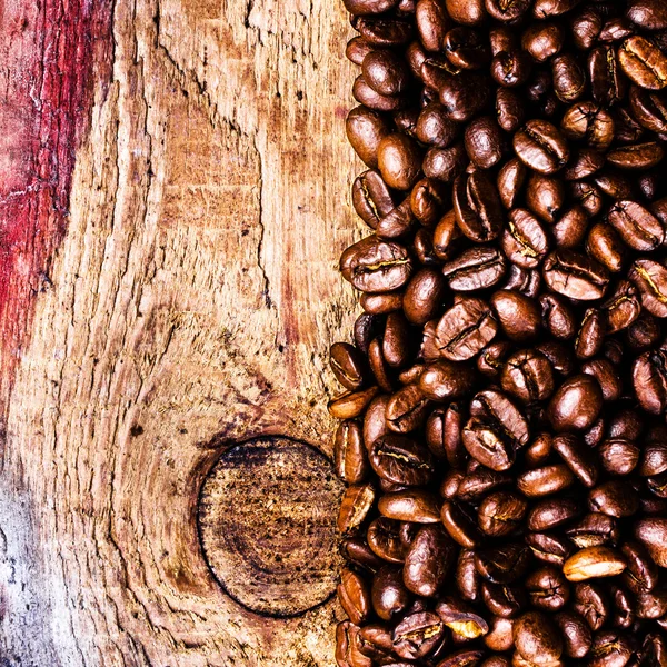 Koffiebonen op oude natuurlijke houten achtergrond — Stockfoto
