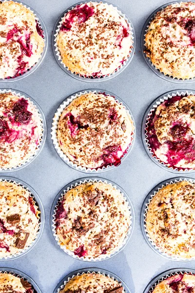 Homemade chocolate muffins with cherry in baking tin top view. — Stock Photo, Image