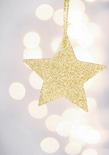 Christmas golden star on Defocused Christmas Bokeh — Stock Photo, Image