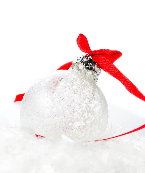 White Christmas Ball with Red Ribbon on a snow