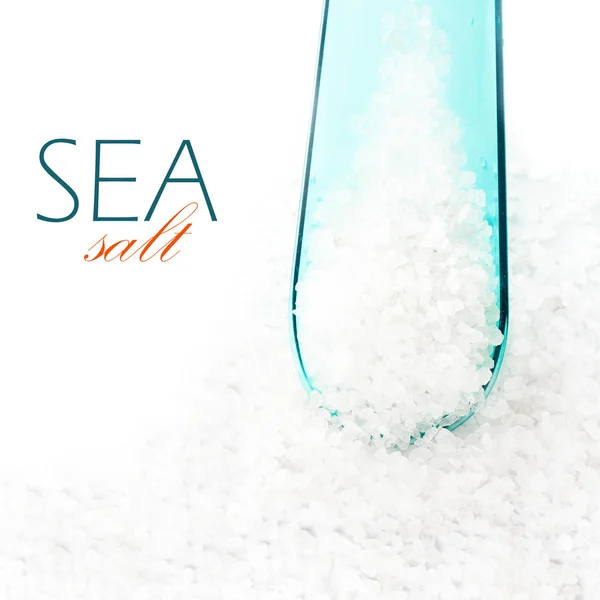 Sal de mar cristalina en cuchara de cuchara de colores sobre fondo blanco — Foto de Stock