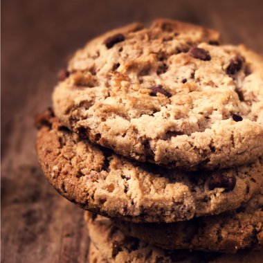 Tahta arka planda çikolata parçalı kurabiyeler.