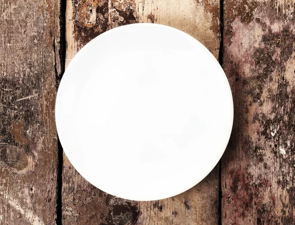 White empty plate with copy space for text on old wooden vintage background — Stock Photo, Image