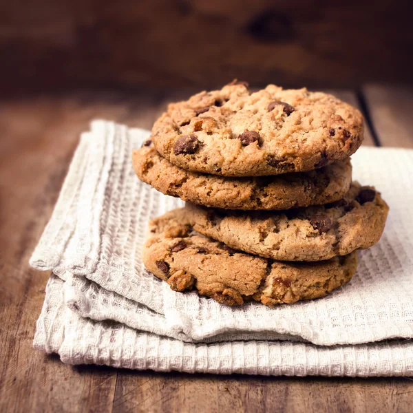 Stacked chocolate chip cookies on white napkin in country style. — Stock Photo, Image