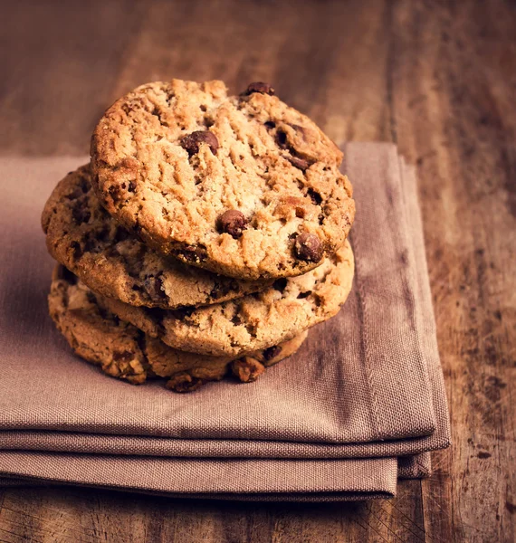 Stacked chocolate chip cookies on brown napkin — Stock Photo, Image