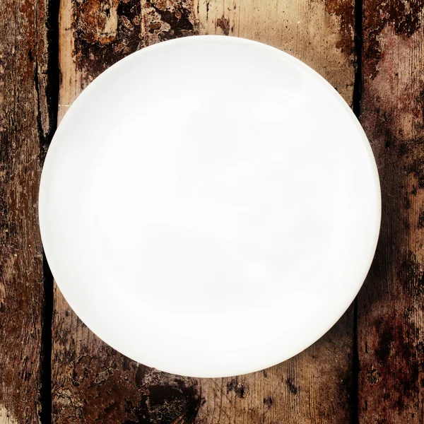Weißer Teller auf altem Holztisch, Plattentrieb — Stockfoto