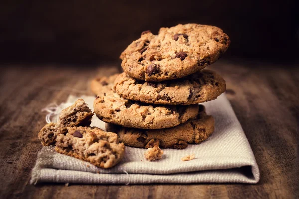 Biscotti al cioccolato su tovagliolo di lino bianco su tavolo di legno . Foto Stock