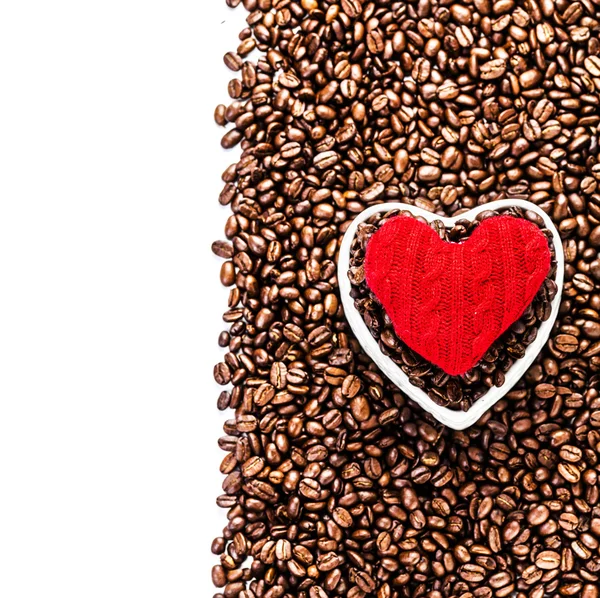 Grains de café torréfiés avec coeur rouge sur fond de grains de café — Photo