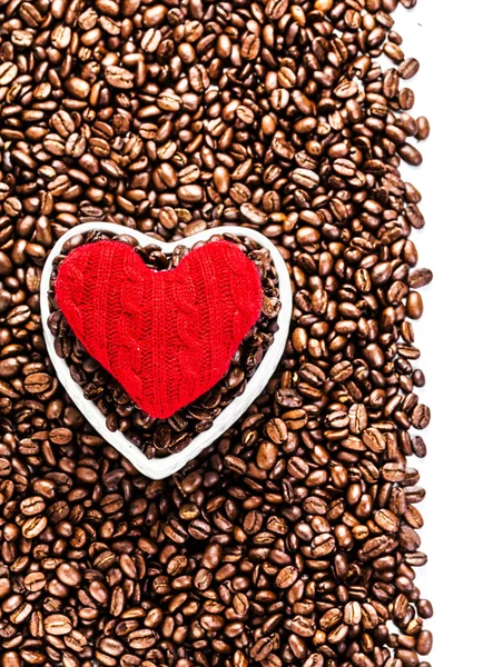 कॉफी बीन्स पार्श्वभूमीवर लाल हार्टसह पीसलेले कॉफी बीन्स — स्टॉक फोटो, इमेज