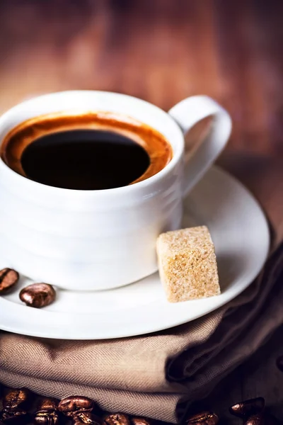 Taza de café con platillo blanco y granos de café tostados —  Fotos de Stock