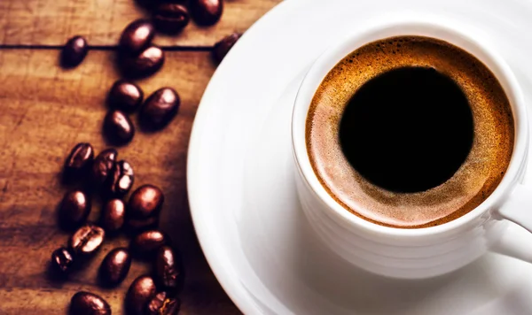 Taza de café con granos de café tostados en madera — Foto de Stock