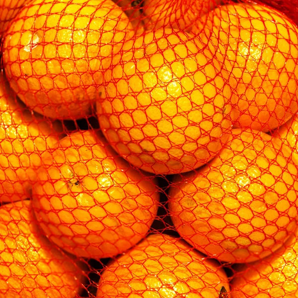 Orange fruits in a string bag — Stock Photo, Image