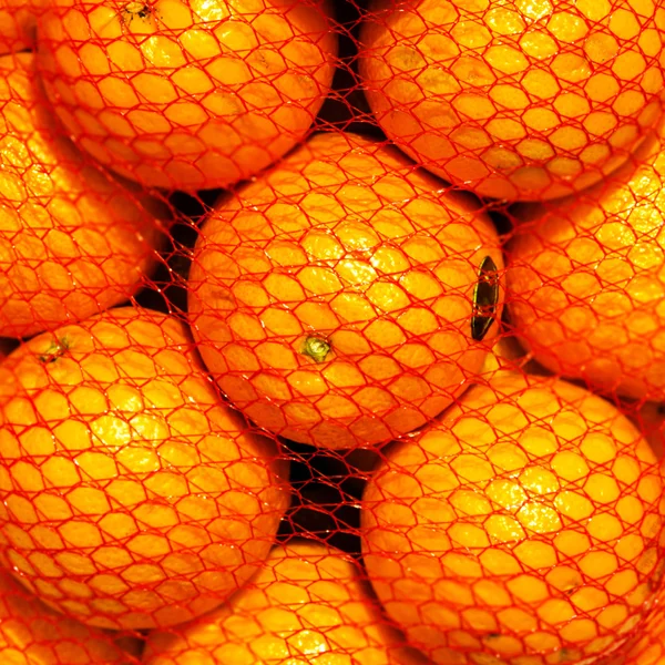 Frutas de naranja en una bolsa de hilo — Foto de Stock