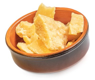 Beyaz arka planda izole edilmiş killi bir kasede parmesan peyniri parçaları.. 