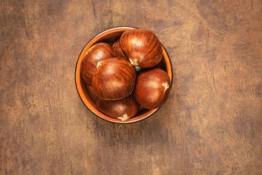 Bir sürü fotokopi alanı olan eski ahşap masadaki tatlı kestaneler. Sonbahar sonbahar konsepti. At kestanesi üst hayat